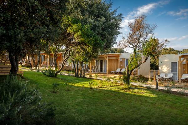 Camping Vestar maisons de vacances sous les arbres