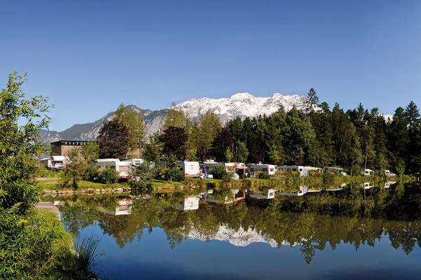 Campingplatz Ferienparadies Natterer See mit Campern und Bergen im Hintergrund