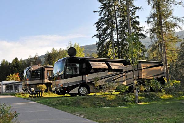 Campingplatz Ferienparadies Natterer See mit zwei geparkten Wohnmobilen.