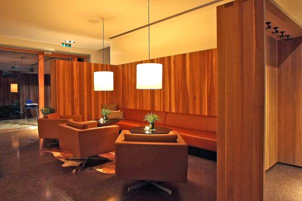 Loungebereich im Ferienparadies Natterer See mit braunen Möbeln und Holzwänden.