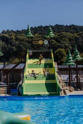 Drie mensen glijden een waterglijbaan af op Europacamping Nommerlayen.