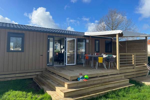 Camping Le Pin Parasol mobil-home avec espace repas extérieur et terrasse.