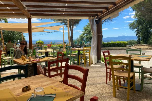 Terrasse des Barco Reale Campingplatzes mit Tischen und Stühlen für das Essen im Freien unter einem Holzvordach.
