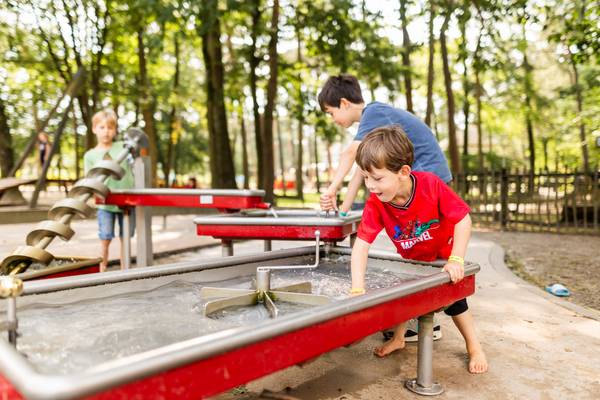 Kinder spielen auf einem Wasserspielplatz im Camping De Paal.
