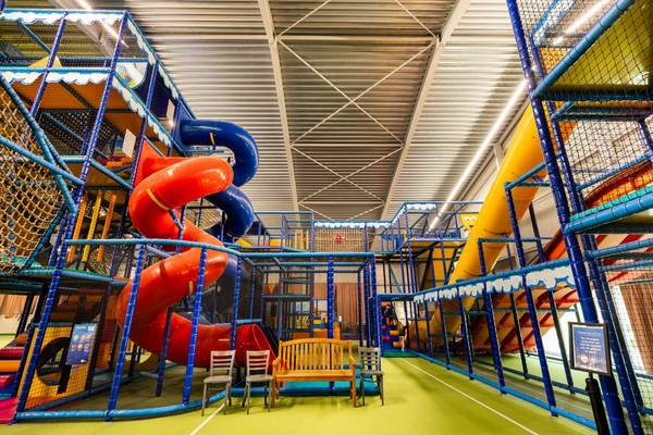 Area giochi al coperto al Camping De Paal con scivoli e sedie