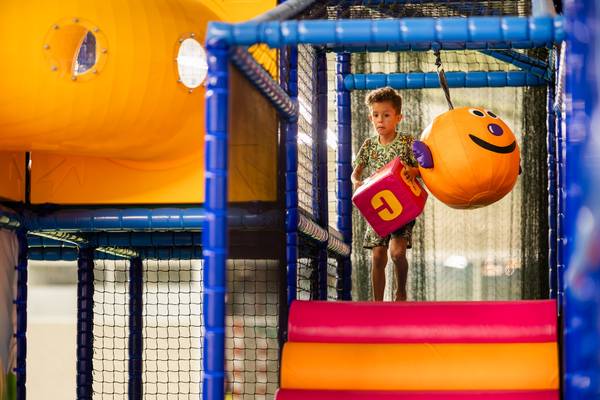 Ein junger Junge spielt im Indoor-Spielplatz von Camping De Paal.