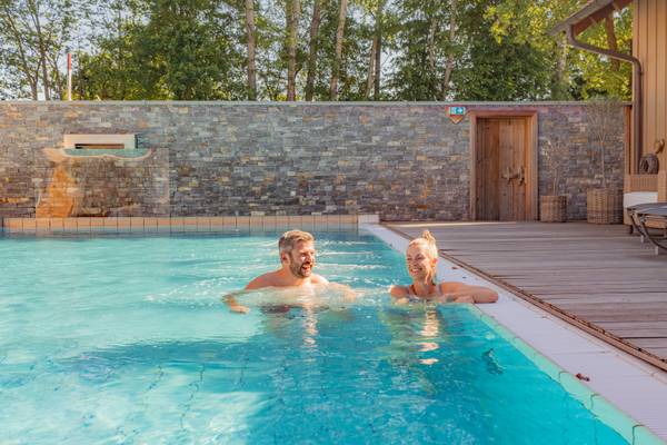 Un couple profite de la piscine au Holmernhof Dreiquellenbad Kur- & Feriencamping