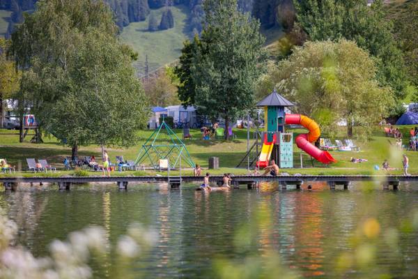 Bambini che giocano al parco giochi sul lago nel campeggio.