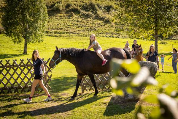 Bambini che cavalcano cavalli al campeggio sportivo Woferlgut
