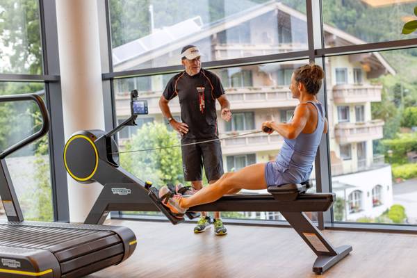Un uomo e una donna fanno allenamento fisico in una palestra con pareti in vetro allo Sportcamp Woferlgut.