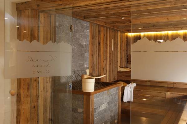 Interno di una sauna in legno con un barile di legno e un asciugamano bianco.