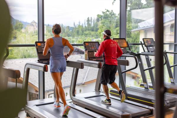 Due persone che corrono su tapis roulant in un centro fitness.
