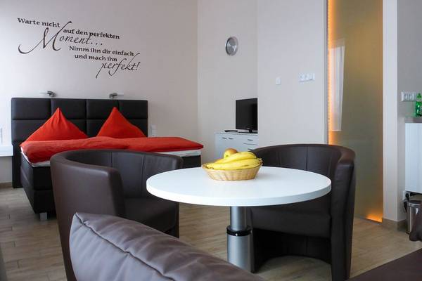 Innenansicht eines Zimmers im LuxOase Freizeitpark mit einem Bett, Tisch und Fernseher.
