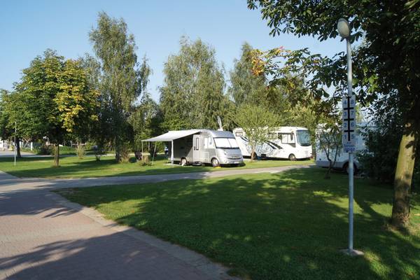 Wohnwagen auf einem Campingplatz im LuxOase Freizeitpark mit Bäumen und Gras.