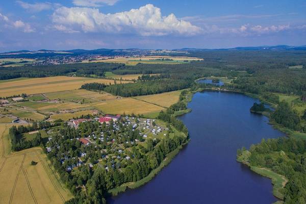 Aerial view of LuxOase Freizeitpark campsite with a lake, trees, and fields.