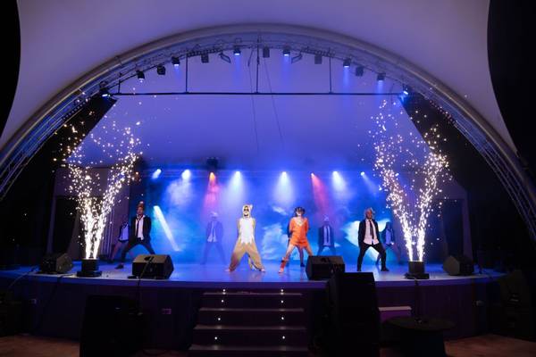 Célébration festive au camping La Marina avec des lumières scintillantes et des artistes sur scène.
