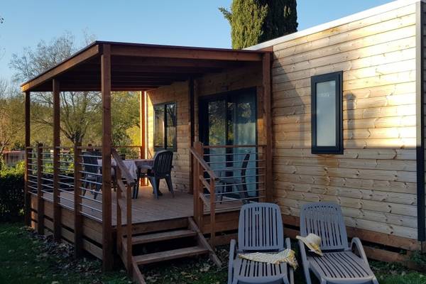 Terrass på Fornella Camping & Wellness Family Resort med træhus og havemøbler.