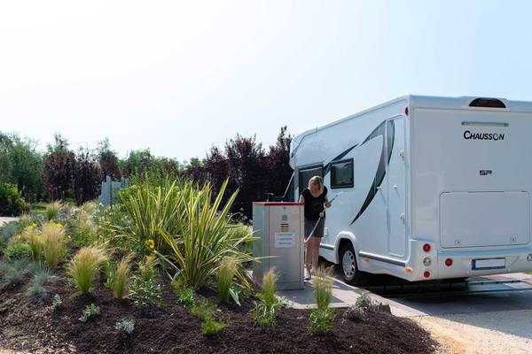 Kvinde tanker sin autocamper på Fornella Camping & Wellness Family Resort