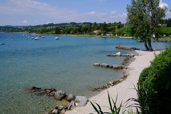 Fornella Camping & Wellness Familieresort ved en sø med både og en kaj.