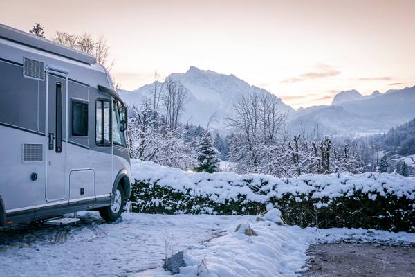 Camping-Wohnmobil im Schnee vor Bergen