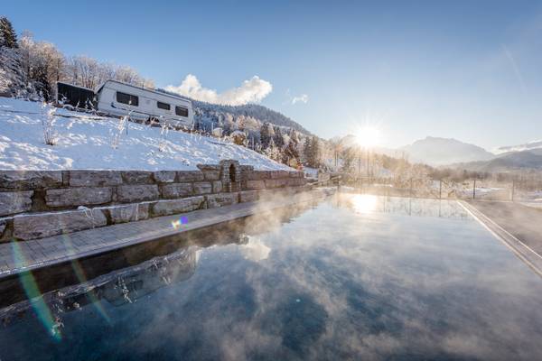 Camping Resort Allweglehen mit einem Wohnwagen auf einem verschneiten Hang und einem Pool im Winter