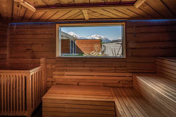 Innenansicht der Sauna im Camping Resort Allweglehen mit Holzwänden und einem Fenster mit Blick auf Berge