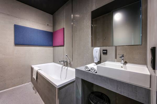 Badezimmer im Camping Resort Allweglehen mit Badewanne, Waschbecken und Spiegel.