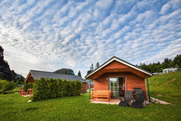 Kleines Holzhaus im Camping Resort Allweglehen mit Gartenmöbeln und bewölktem Himmel