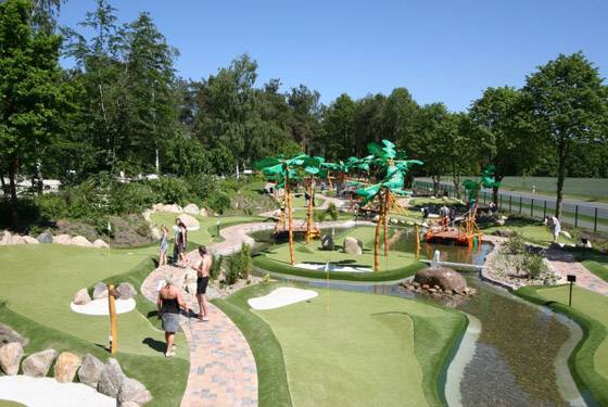Minigolfbane på Südsee-Camp camping med tropiske elementer og et lille vandelement.