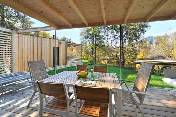 Esstisch mit Stühlen auf einer Holzterrasse im Ferienparadies Natterer See.