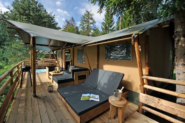 Terrasse des Ferienparadies Natterer See Campingplatz mit Zelt und Loungemöbeln
