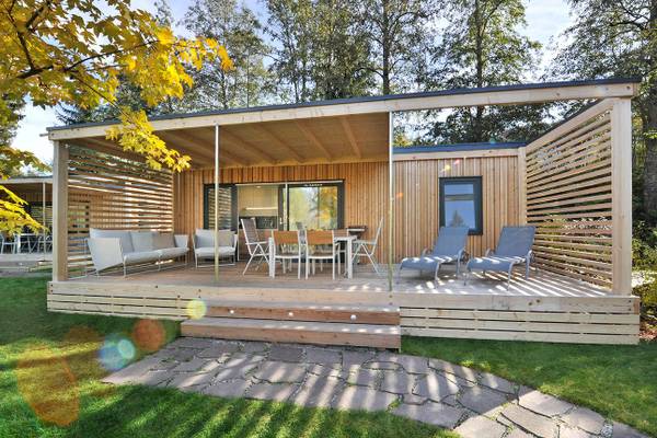 Ferienparadies Natterer See Camping-Unterkunft mit Holzterrasse, Möbeln und Garten.