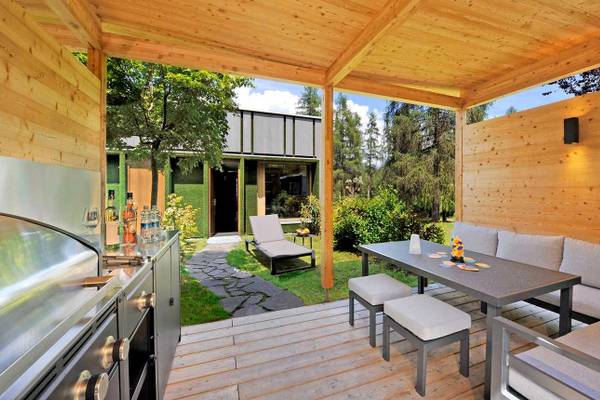 Campingplatz Ferienparadies Natterer See, Sitzbereich im Freien mit Tisch, Stühlen und Blick in den Garten.