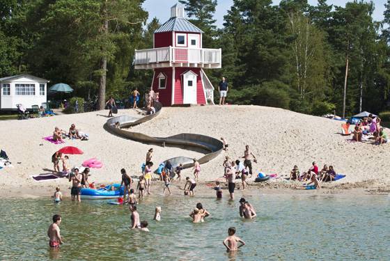 Strand ved Sudsee Camp med en rød tårn og en rutsjebane i sandet