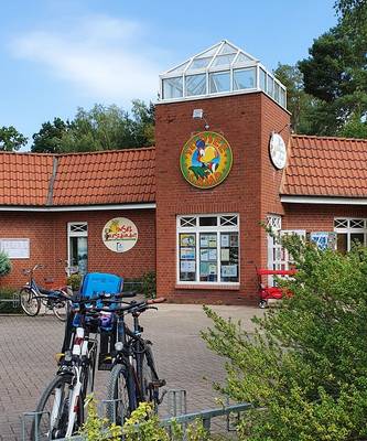 Foto af Sudsee-Camp bygningen forfra med parkerede cykler.