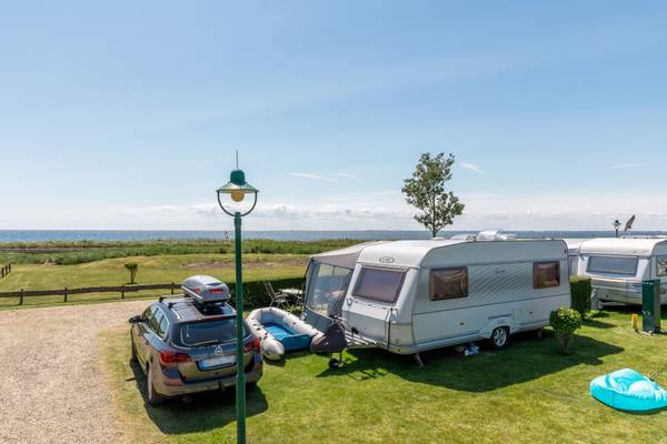 Camping Insel-Camp Fehmarn con caravanas y un coche en un día soleado