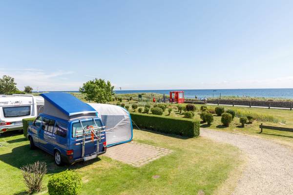 Autocaravanas aparcadas en el camping Insel-Camp Fehmarn con el océano al fondo
