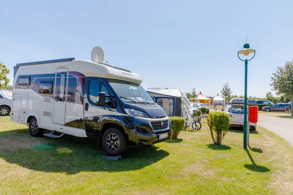 Una autocaravana blanca y azul aparcada en el camping de Insel-Camp Fehmarn.