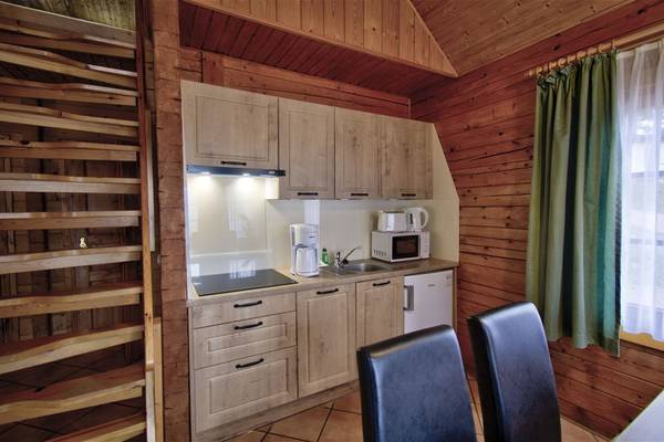 Interior view of the kitchen at Camping- und Ferienpark Havelberge with wooden walls and furniture.