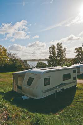 RV parked in a campsite with a lake in the background