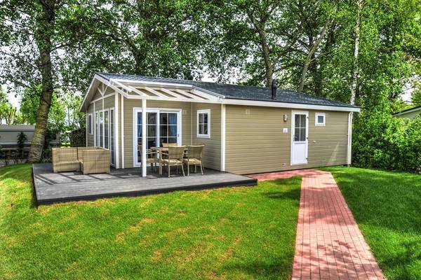 Außenansicht eines Chalets am Campingplatz Wulfener Hals mit Terrasse und Gartenmöbeln.