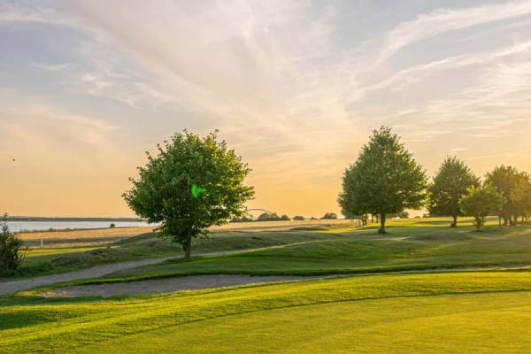 Golfplatz am Wulfener Hals mit aufgehender Sonne im Hintergrund