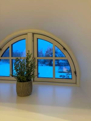 Ventana de arco con planta vista del paisaje nevado en el Feddet Strand Resort