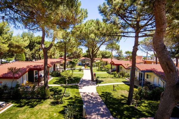 Vue aérienne du Camping Village Le Brasilia avec plusieurs chalets et chemins.