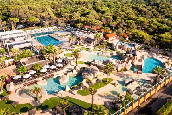 Vue aérienne du Camping Village Le Brasilia avec plusieurs piscines et bungalows.