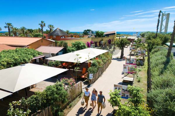 Vue aérienne du Camping Village Le Brasilia avec des gens marchant sur un chemin.