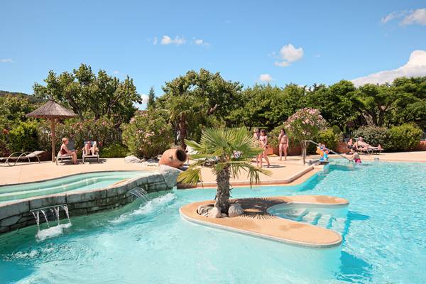 Piscina al aire libre en el camping Nature Parc L`Ardéchois con gente relajándose.