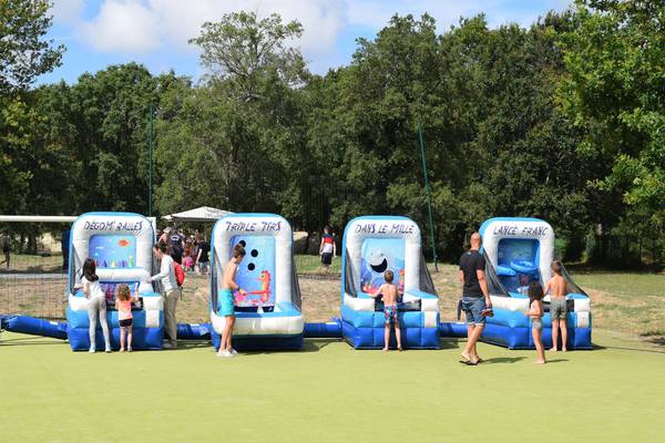 Drie opblaasbare spellen met Franse tekst op een camping met spelen mensen