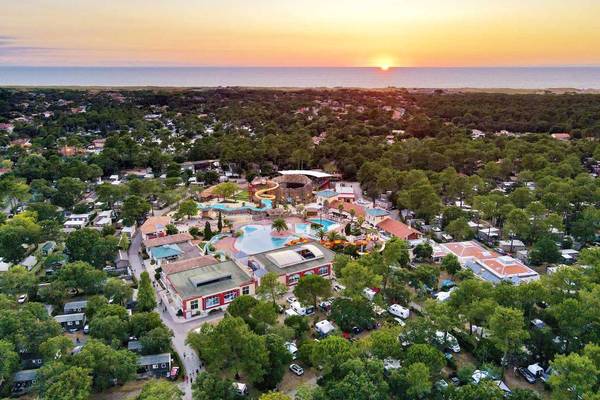 Aerial view of Camping Village Sylvamar with a sunset in the background.