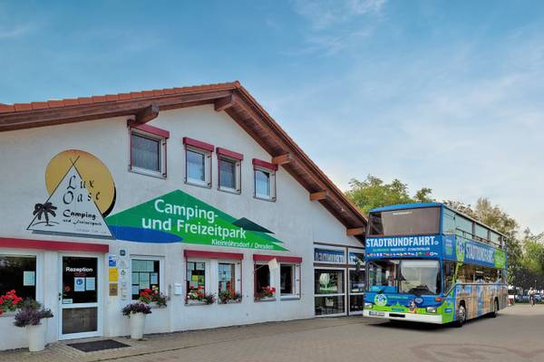 Ein Gebäude des Camping und Freizeitparks mit einem Doppeldeckerbus davor.